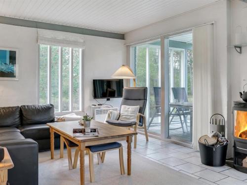 a living room with a couch and a table and a fireplace at Holiday Home Torhild - 150m from the sea by Interhome in Martofte