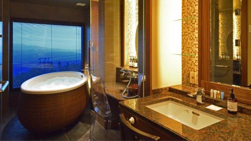 a bathroom with a large tub and a sink at Akakura Kanko Hotel in Myoko