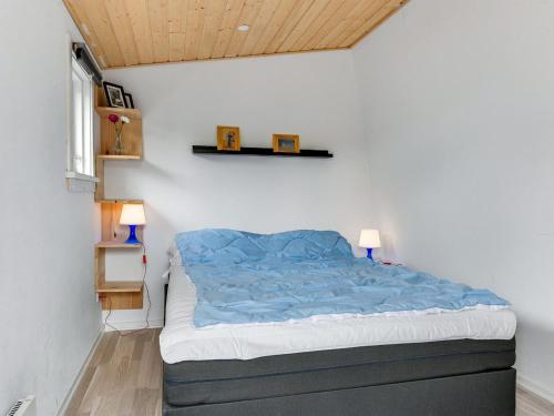 a bedroom with a bed with a blue comforter at Holiday Home Hardina - 300m from the sea by Interhome in Martofte