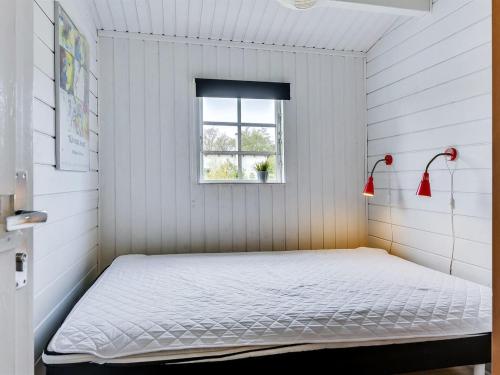 a bed in a white room with a window at Holiday Home Hardina - 300m from the sea by Interhome in Martofte