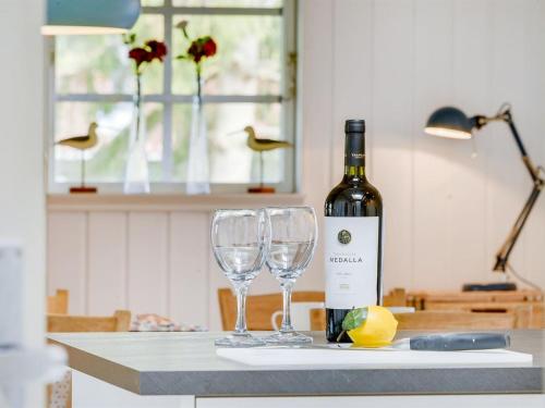 a bottle of wine and two glasses on a counter at Holiday Home Hardina - 300m from the sea by Interhome in Martofte