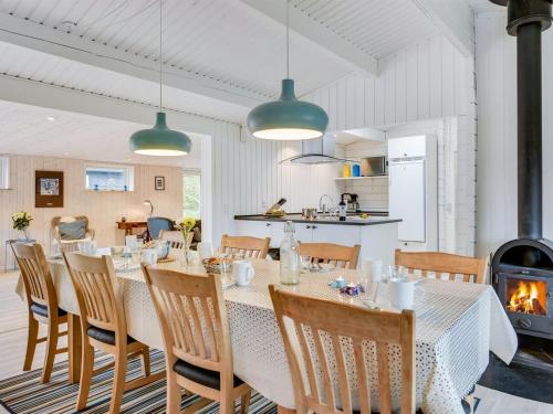 a dining room with a table and chairs and a fireplace at Holiday Home Hardina - 300m from the sea by Interhome in Martofte