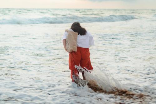 a woman walking in the water on the beach at Moi Induruwa by DBI in Bentota