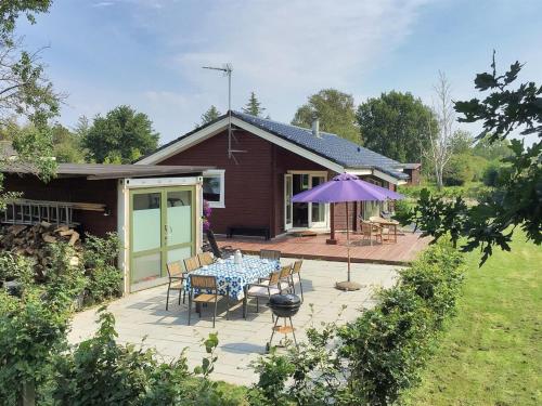 a patio with a table and a purple umbrella at Holiday Home Karanfilka - 900m from the sea by Interhome in Gedser
