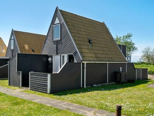 a house with a black roof at Holiday Home Pihla - 50m from the sea by Interhome in Gedser