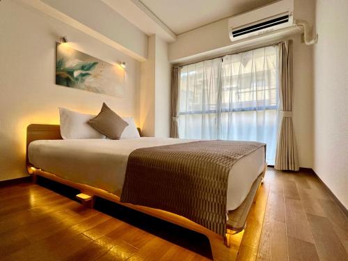 a bedroom with a large bed and a window at Comfy Home Kikukawa in Tokyo