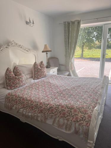 a bedroom with a large bed with a window at The Old Stone Trough Country Hotel in Kelbrook