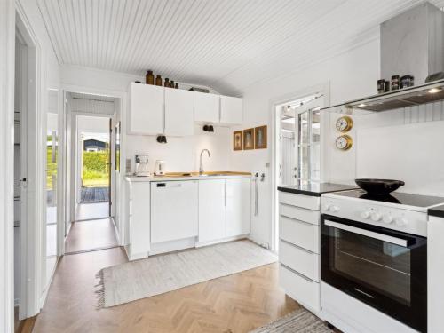 a kitchen with white cabinets and a sink at Holiday Home Thomas - 120m from the sea by Interhome in Otterup