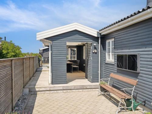 a blue house with a bench on a patio at Holiday Home Sazur - 75m from the sea by Interhome in Mesinge