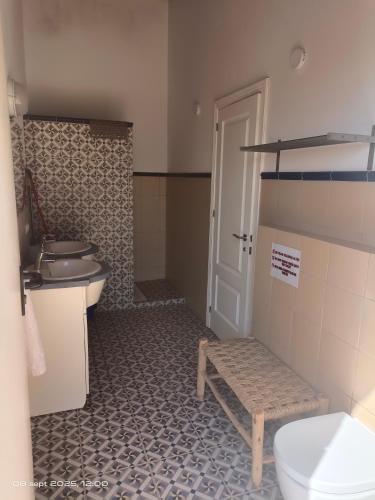 a bathroom with a toilet and a bench in it at Villavera in Villaverde del Río