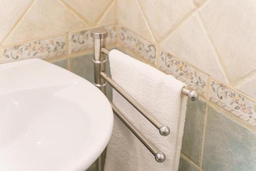 a bathroom with a toilet and towels on a wall at Dimora Matine Pisticci in Pisticci
