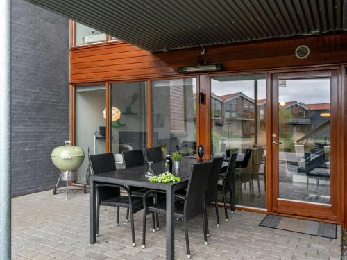 a black dining table and chairs on a patio at Apartment Allyson - 450m from the sea by Interhome in Bogense