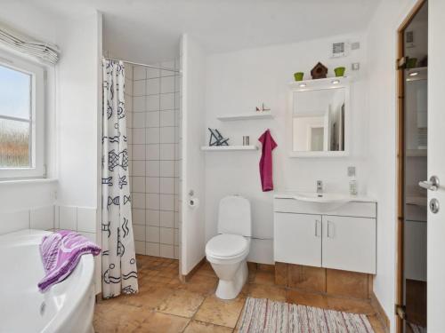 a white bathroom with a toilet and a sink at Holiday Home Daniela - 300m from the sea by Interhome in Bro
