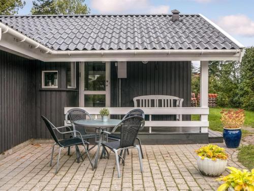 a patio with a table and chairs and a white pergola at Holiday Home Stasia - 75m from the sea by Interhome in Middelfart