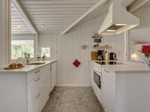 a kitchen with white cabinets and a sink at Holiday Home Stasia - 75m from the sea by Interhome in Middelfart
