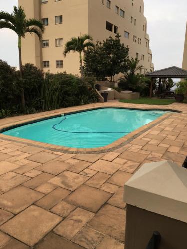 a swimming pool in front of a building at Ballito Sands in Ballito