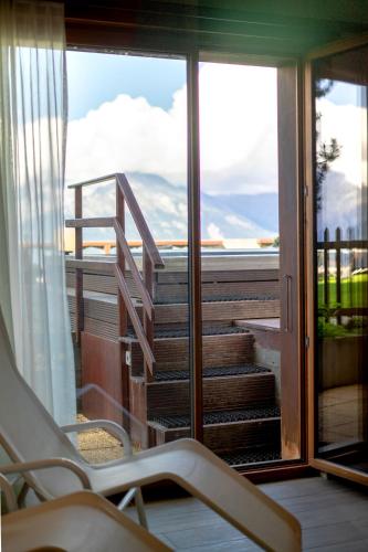 a room with a balcony with a view of the mountains at Hôtel Chalet Royal in Veysonnaz