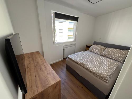 a small bedroom with a bed and a window at NEU Design Loft nähe Medienhafen mit Balkon in Düsseldorf
