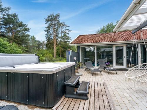 a hot tub on a deck next to a house at Holiday Home Sverker - 300m from the sea by Interhome in Rødby