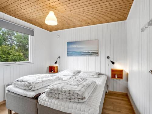 two beds in a bedroom with white walls at Holiday Home Sverker - 300m from the sea by Interhome in Rødby