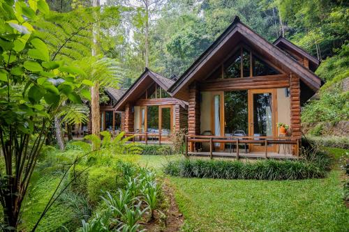 a log cabin in the forest with a yard at Taman Wisata Bougenville by Kozystay in Malabar