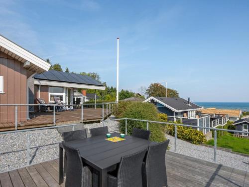 eine Terrasse mit einem schwarzen Tisch und Stühlen auf einer Terrasse in der Unterkunft Holiday Home Ebbeline - 150m from the sea by Interhome in Binderup Strand