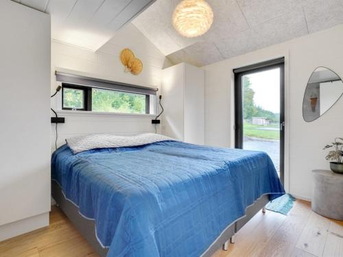 a bedroom with a blue bed and a window at Holiday Home Gunborg - 400m from the sea by Interhome in Sjølund