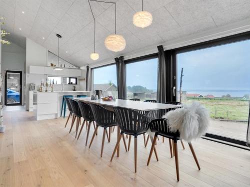 a kitchen and dining room with a table and chairs at Holiday Home Gunborg - 400m from the sea by Interhome in Sjølund