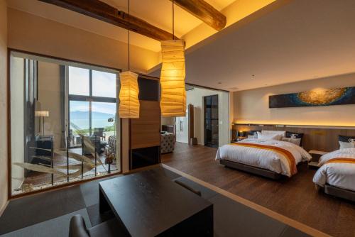 a bedroom with a bed and a desk and a window at 富士青藍 in Numazu