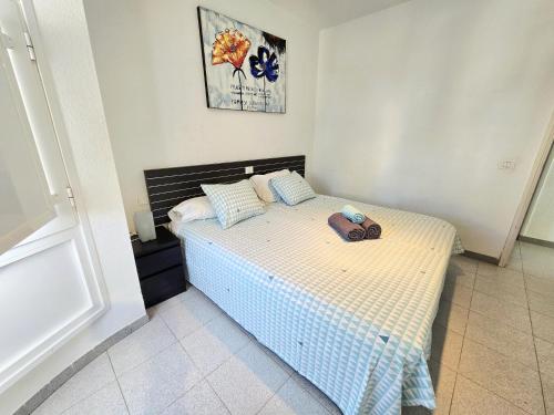 a bedroom with a bed with a purse on it at Apartamentos Medano - Playa Grande in El Médano