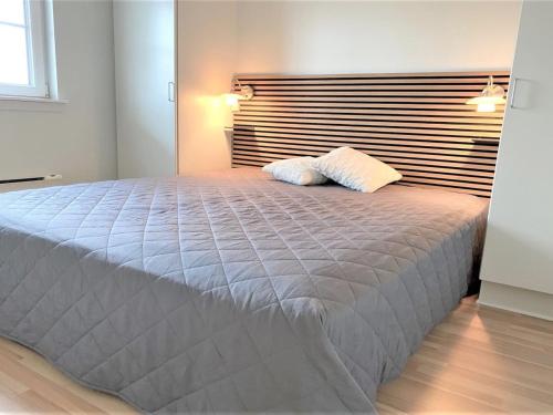 a bedroom with a large bed with two pillows on it at Holiday Home Eike - 250m from the sea by Interhome in Bro
