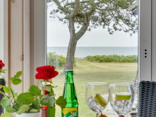 two wine glasses sitting on a table in front of a window at Holiday Home Sigurd - 20m from the sea by Interhome in Middelfart