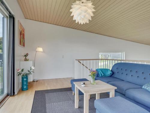a living room with a blue couch and a table at Holiday Home Lyly - 100m from the sea by Interhome in Asperup