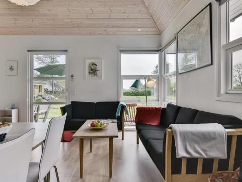 una sala de estar con un sofá y una mesa en Holiday Home Wrage - 500m from the sea by Interhome, en Ny Vemmenæs
