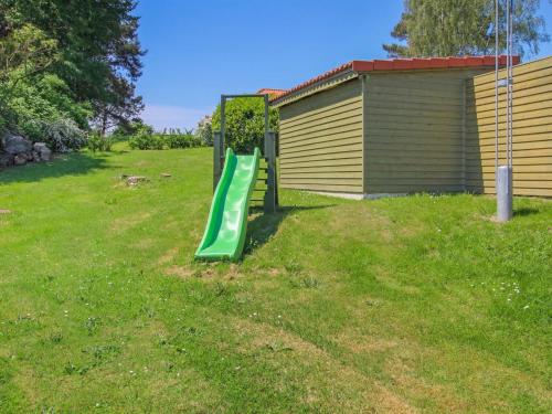 a green slide in a yard next to a building at Holiday Home Berglind - 850m from the sea by Interhome in Hejls