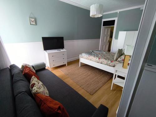 a living room with a couch and a bed at Cantinho da Cruz in Ponta Delgada