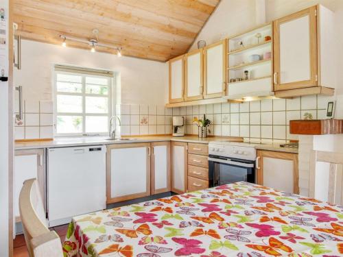 a kitchen with a table with a flowered table cloth at Holiday Home Berglind - 850m from the sea by Interhome in Hejls
