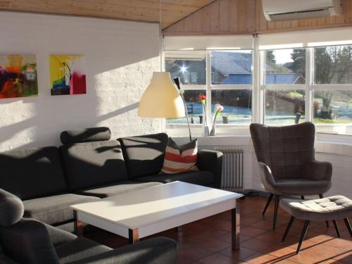 a living room with a couch and chairs and a table at Holiday Home Berglind - 850m from the sea by Interhome in Hejls