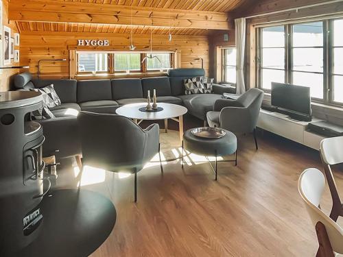 a living room with a couch and tables and chairs at Holiday Home Stacie - 10m from the sea by Interhome in Gedser