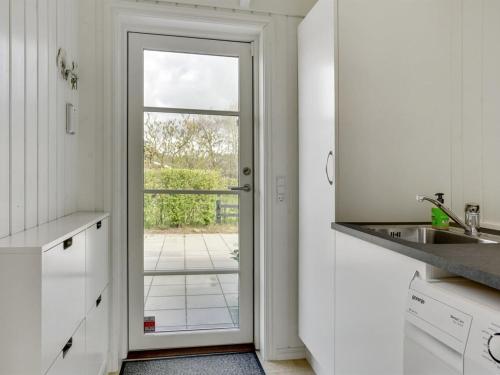 a kitchen with a door leading to a patio at Holiday Home Antti - 350m from the sea by Interhome in Millinge