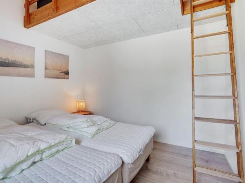 two beds in a room with a ladder at Holiday Home Haley - 150m from the sea by Interhome in Millinge