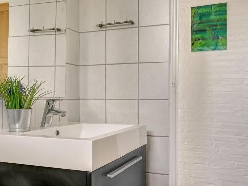 a white bathroom with a sink and a shower at Holiday Home Undine - 300m from the sea by Interhome in Middelfart