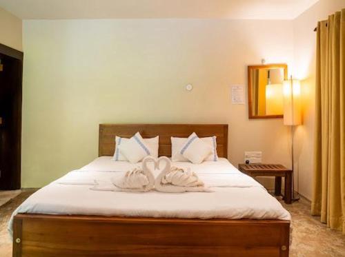 a bedroom with two swans towels on a bed at Ceylon Kingsmen Garden - Katunayake Airport Transit Hotels in Negombo