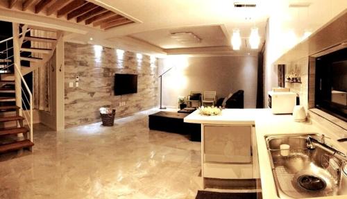 a kitchen with a sink and a stone wall at Oh Happy Day Jeju in Jeju