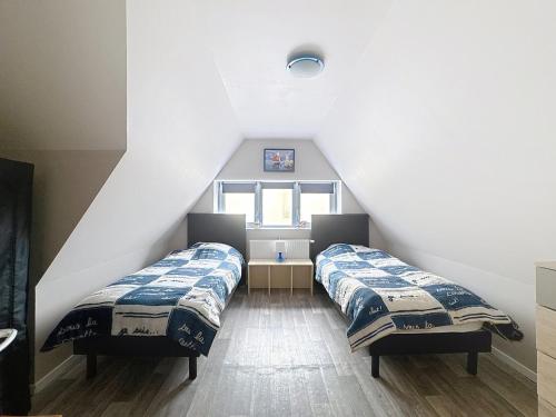 2 Betten in einem Dachzimmer mit Fenster in der Unterkunft Chez Bertrand - Détente en bord de Mer in Bray-Dunes