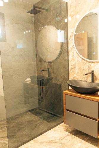 a bathroom with a shower with a sink and a mirror at Casa Lumina in Gročanska Ada