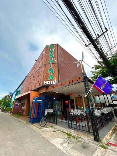 a building with a sign on the side of it at Paksina Hotel in Narathiwat