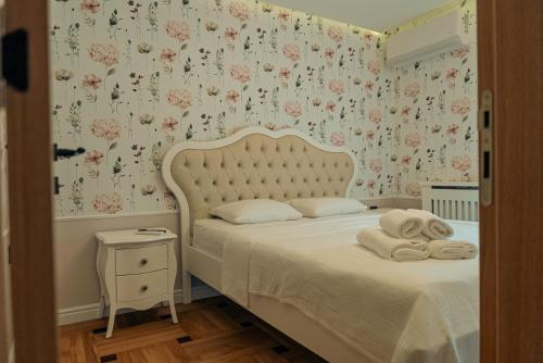 a bedroom with a bed with floral wallpaper at Casa Lumina in Gročanska Ada