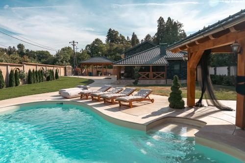 a swimming pool with benches and a pavilion at Casa Lumina in Gročanska Ada