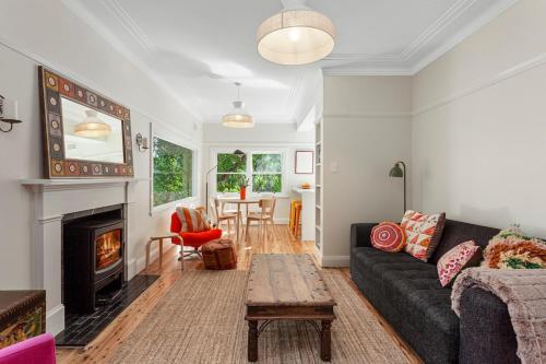 a living room with a couch and a fireplace at Cooinda Mountain Retreat in Blackheath
